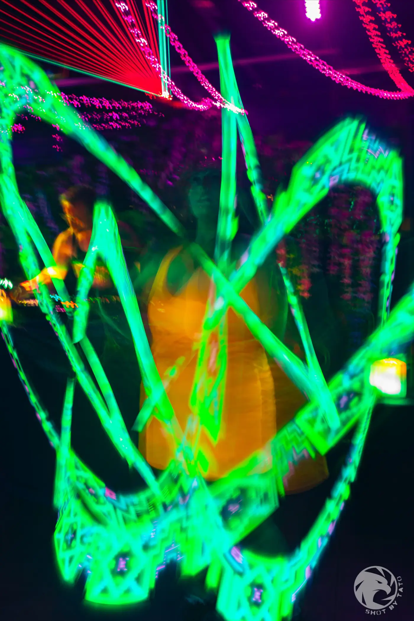 Green and magenta light trails moving through a Pluto Events dance floor