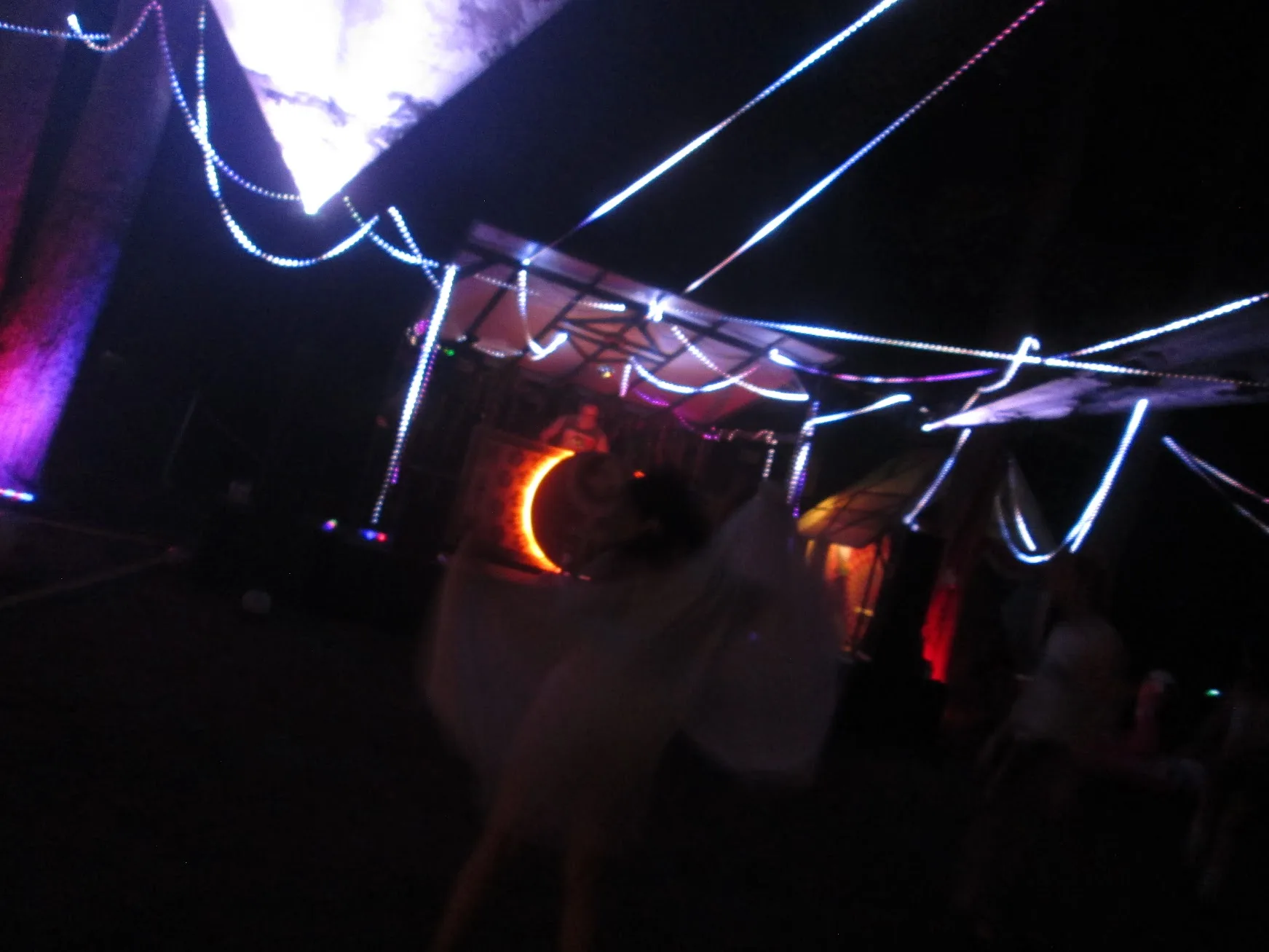 Glowing string lights and fabric canopies above the nighttime dance floor