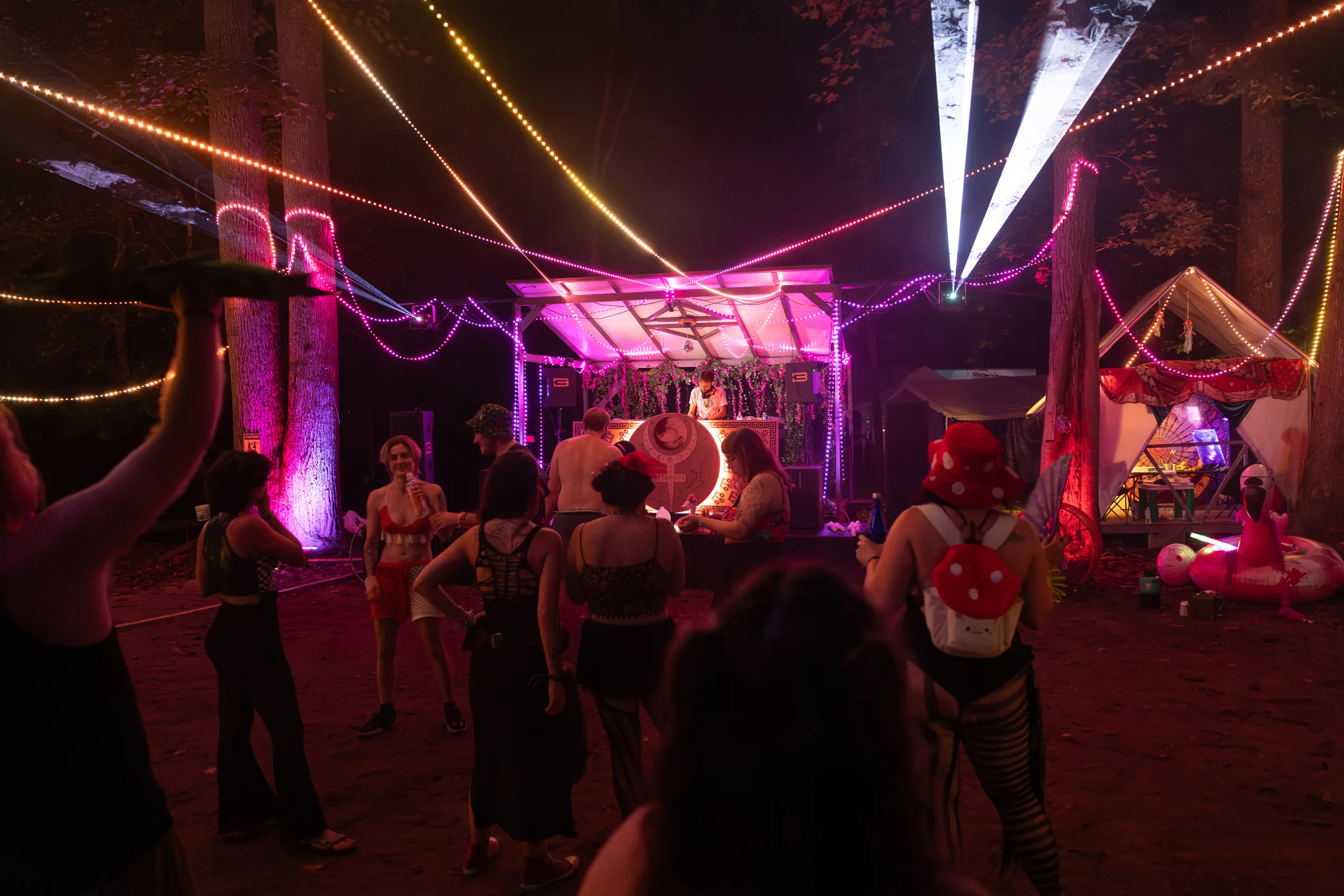 A crowd dancing in front of a pink-lit DJ stage at ManaFest 2026